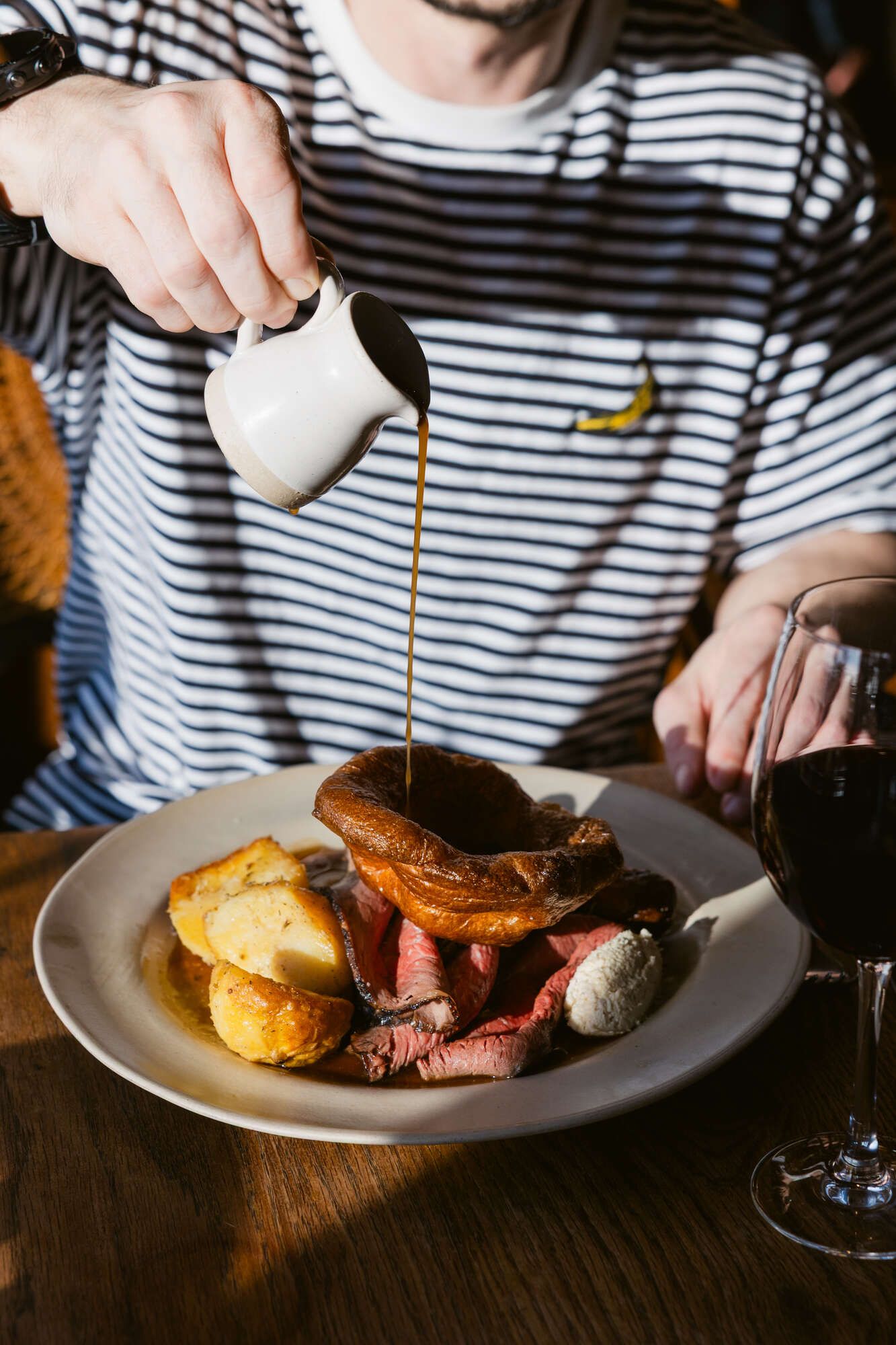 Gravy pouring on roast dinner in the sunshine