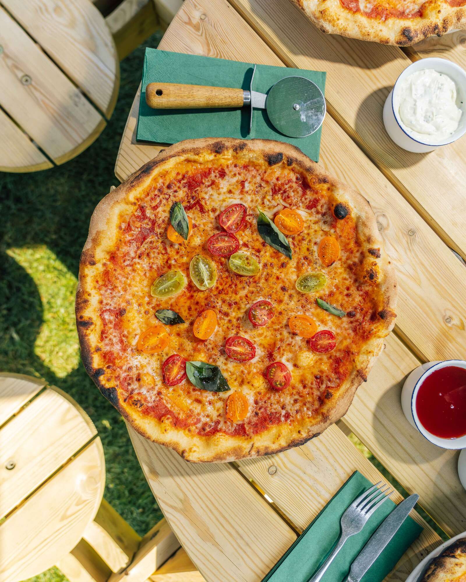 Margarita Hand stretched Pizza with cutter eating outside