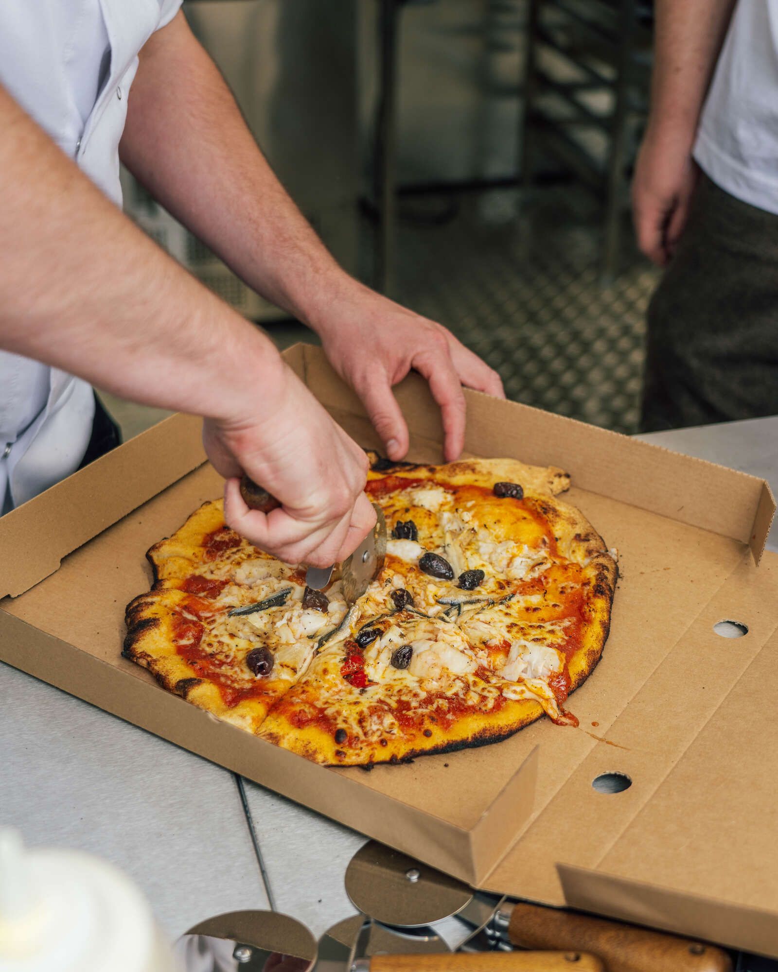 Cutting pizza in a takeaway box