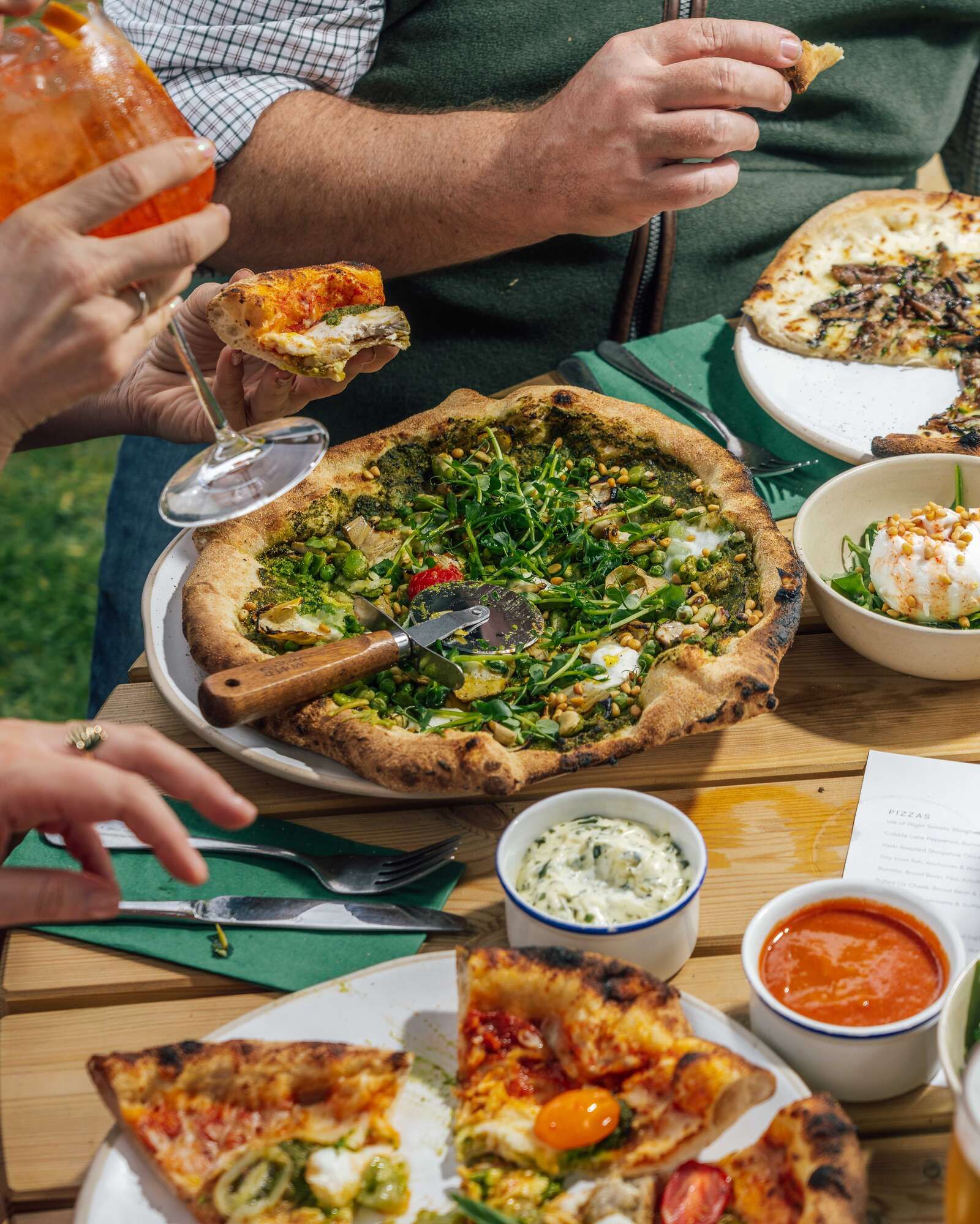 vegetarian pizza served outside with drinking spritz